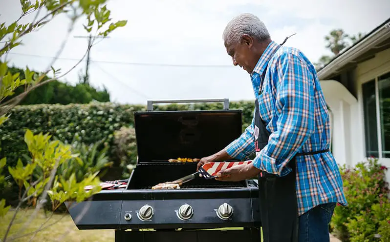 Man in apron grilling